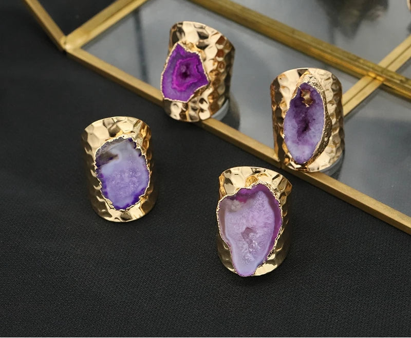 Gold-rimmed purple stone rings on a reflective surface with GLSEEWO branding.